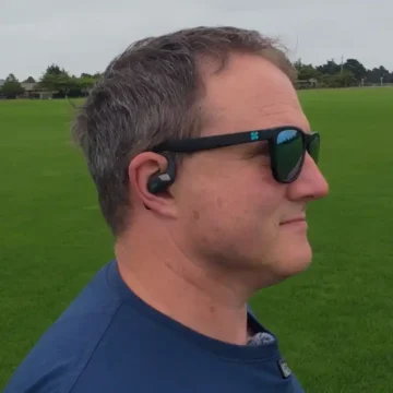wearing shokz openfit 2 earbuds whilst wearing glasses in a park